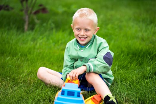 Little boy playing with his toys in the garden