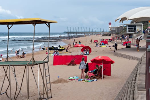DURBAN, SOUTH AFRICA - JULY 09, 2016: Locals and tourists on the beach near the Millennium Pier and lighthouse in Umhlanga Rocks