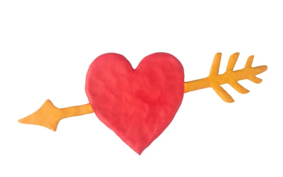 A red clay heart with an yellow clay arrow isolated on white background