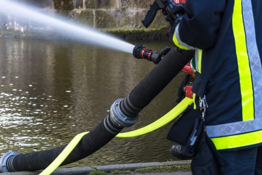 Fire department sprays extinguishing water from fire hoses during an exercise..