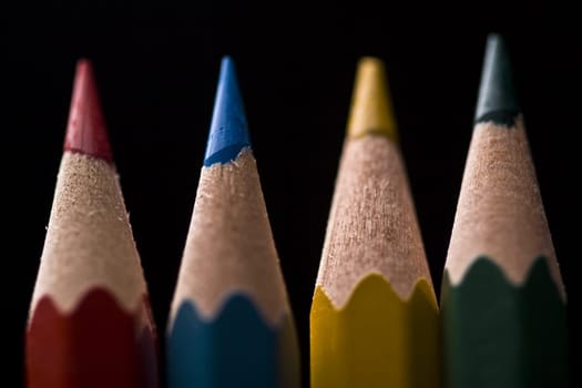 Macro of group of colored pencils with shallow depth of field on black background