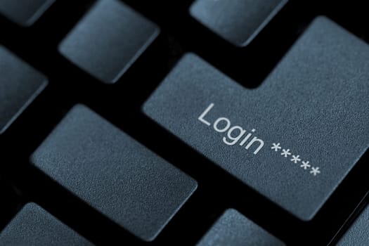 Horizontal close up of black keys on a keyboard with the word login on one of them