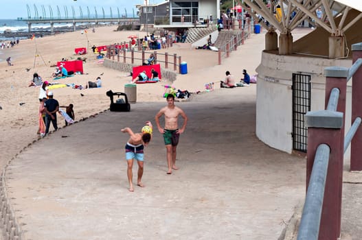 DURBAN, SOUTH AFRICA - JULY 09, 2016: Locals and tourists on the beach near the Millennium Pier and lighthouse in Umhlanga Rocks