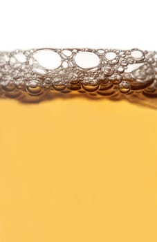 Vertical close up of beer froth isolated on white background