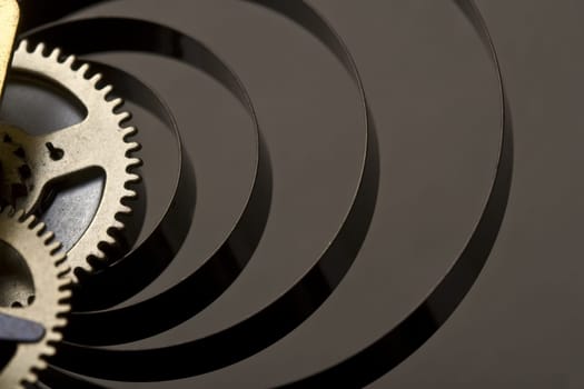 Horizontal close up on the golden cogs of a mechanical clock