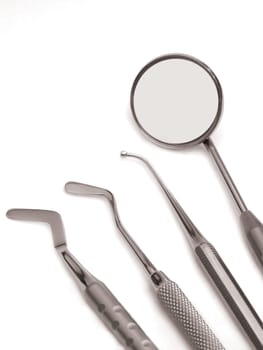 Set of chrome dental tools, viewed from the top isolated on white background