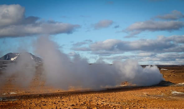 Horizontal view of steam hot springs coming out of the ground in the volcanic valley near Myvatn baths in Iceland