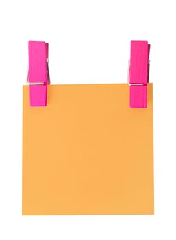 Orange paper note held by two pegs on white background