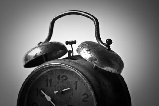 Horizontal black and white side view of an old alarm clock