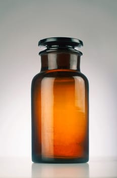 One old medical brown glass jar isolated on grey background