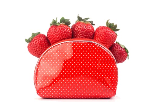 Five fresh strawberries in a plastic dotted red purse