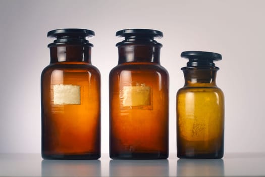 Three old medical brown glass jars isolated on grey  background