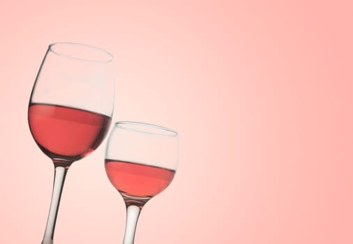 Horizontal front view of two rose wine glasses isolated on pink background