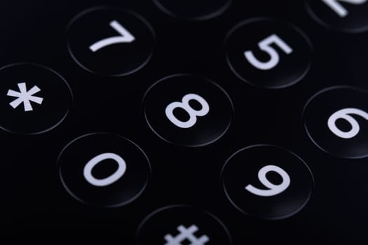 Horizontal top view close up of the keypad of a telephone with numbers showing