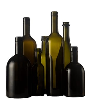 Horizontal front view of a group of empty wine bottles of different sizes, shapes and colorisolated on white background.