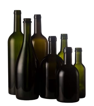 Horizontal front view of a group of empty wine bottles of different sizes, shapes and colorisolated on white background.