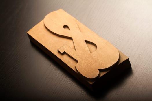 Ampersand wooden sign on black wood texture