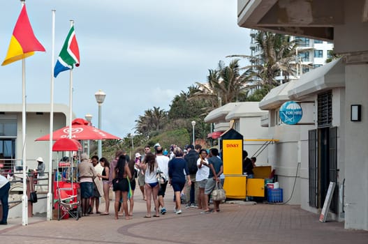 DURBAN, SOUTH AFRICA - JULY 09, 2016: Locals and tourists on the promenade near the Millennium Pier and lighthouse at Umhlanga Rocks beach