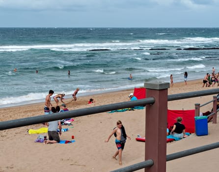 DURBAN, SOUTH AFRICA - JULY 09, 2016: Locals and tourists on the beach near the Millennium Pier and lighthouse in Umhlanga Rocks