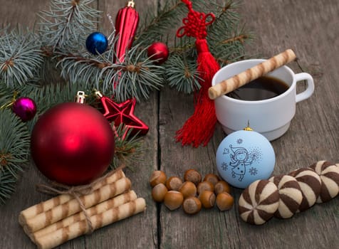 coniferous branch with Christmas tree decorations, coffee, nutlets and baking, the subject Christmas and New Year