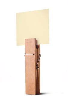 wooden peg holding a yellow note isolated on white background