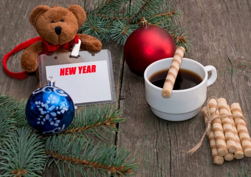 coniferous branch, coffee, baking and toy bear with a label New Year, the subject Christmas and New Year