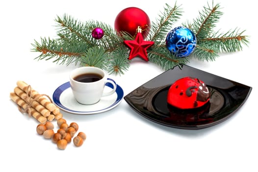 plate with red cake, coffee and Christmas tree decorations on a coniferous branch, a still life, the subject Christmas and New Year