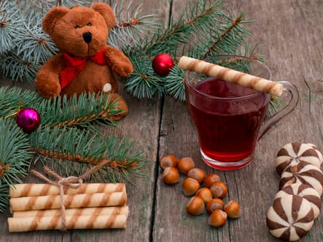 fir-tree branch, toy bear, tea, baking and nutlets, subject holidays Christmas and New Year
