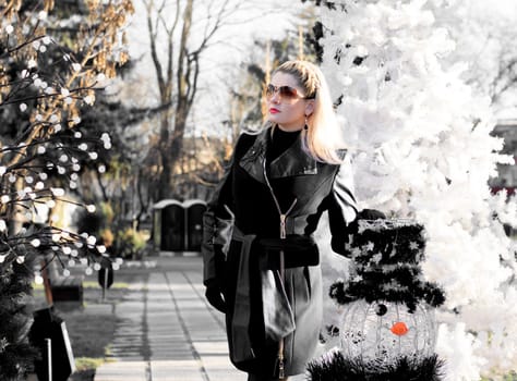 the beautiful woman near a fir-tree and a snowman, the black-and-white photo, a subject of the woman and holidays Christmas and New Year