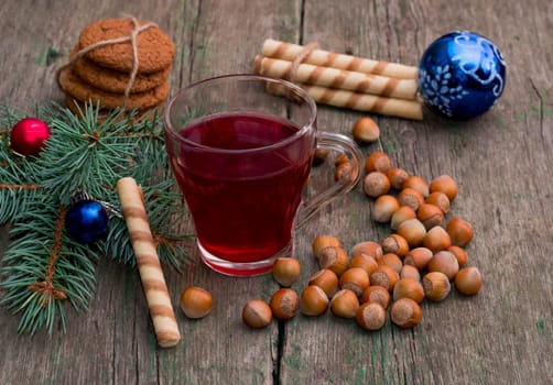 coniferous branch with Christmas tree decorations, tea, sweets and nutlets, the subject Christmas and New Year
