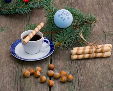 coffee, a fir-tree branch with Christmas tree decorations, nutlets, a subject holidays Christmas and New Year
