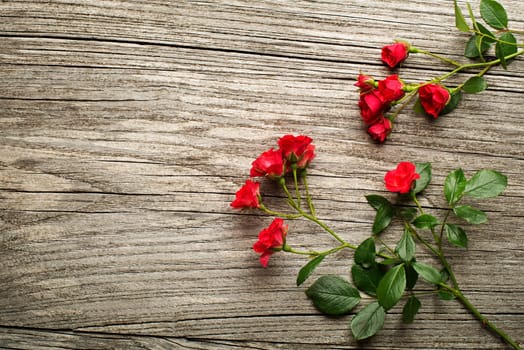 Red roses on wooden background overhead shoot