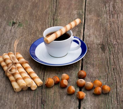 coffee, baking in the form of tubules and nutlets, on a wooden table, a subject of sweet and drinks