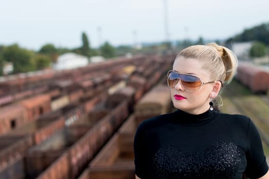 the woman's portrait on the bridge against railway cars, a subject beautiful women and railway tracks