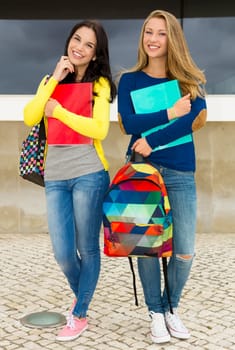 Two happy and beautiful teenage students in the school