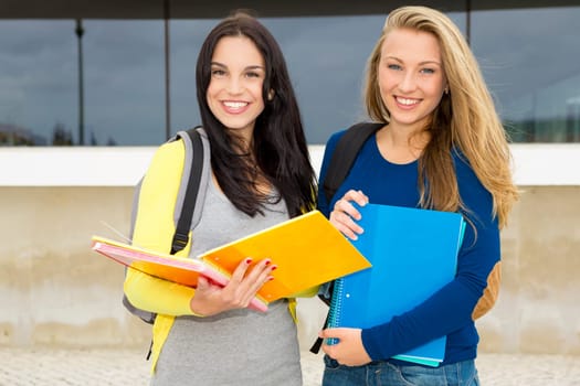 Two happy and beautiful teenage students in the school
