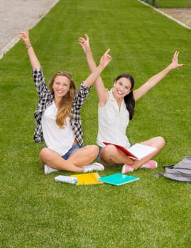 Happy best friends sitting on the grass and having a good time