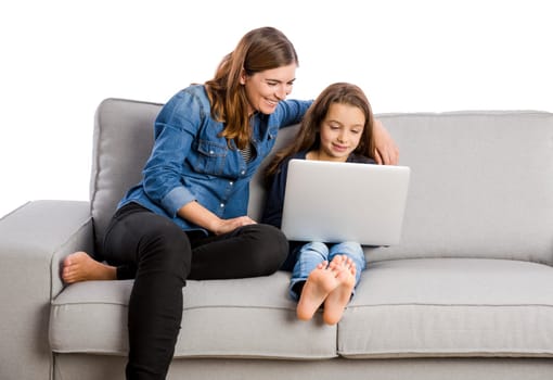 Mother teaching her little daughter working with a laptop