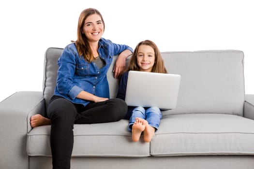 Mother teaching her little daughter working with a laptop
