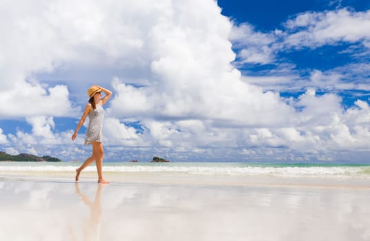 Beautiful woman walking in the beautiful beach of Praslin, Seychelles