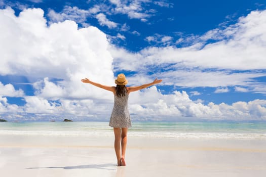 Beautiful woman walking in the beautiful beach of Praslin, Seychelles