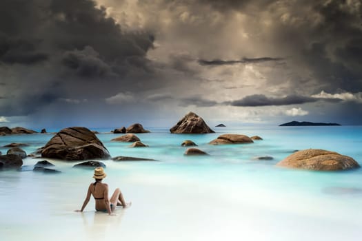 Woman resting at the beautiful Anze Lazio beach, Seychelles