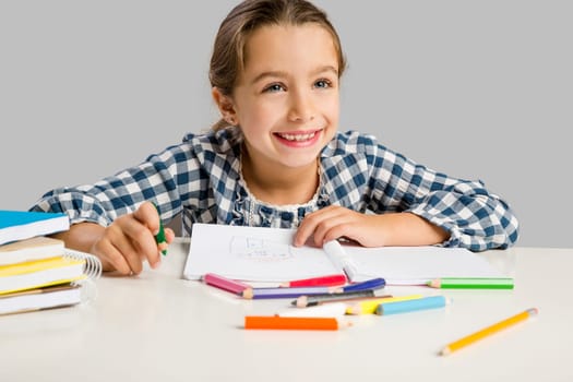 Little girl at school making drawings and painting
