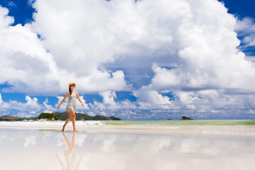Beautiful woman walking in the beautiful beach of Praslin, Seychelles