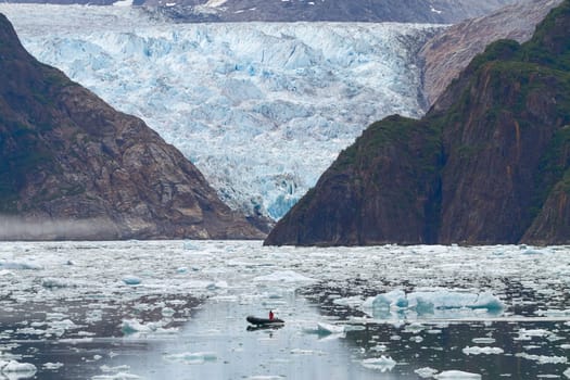 Man in Boat in Front of Sawyer Glacier at Tracy Arms Fjords in Alaska United States.