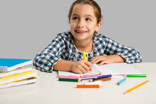 Little girl at school making drawings and painting
