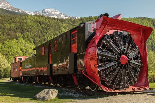SKAGWAY, ALASKA, USA - MAY 31, 2011: Old Snow Blower Train and Trees in the Background