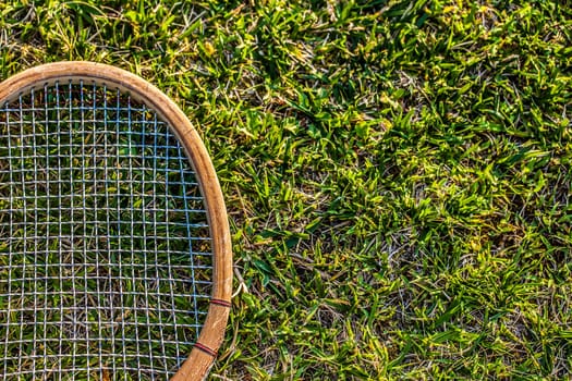 Vintage wood tennis racket on grass garden