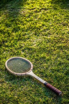 Vintage wood tennis racket on grass garden