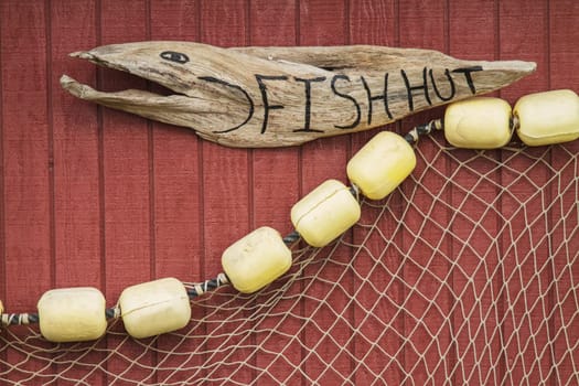 Wooden Carved Sign with Net on House of Fisherman in Icy Strait Alaska